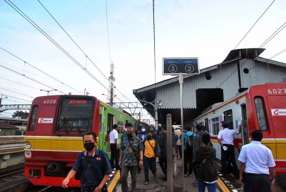 Sejumlah penumpang berjalan di dekat gerbong KRL Commuter Line di Stasiun Bogor, Jawa Barat, Rabu (15/4/2020). ANTARA/Arif Firmansyah