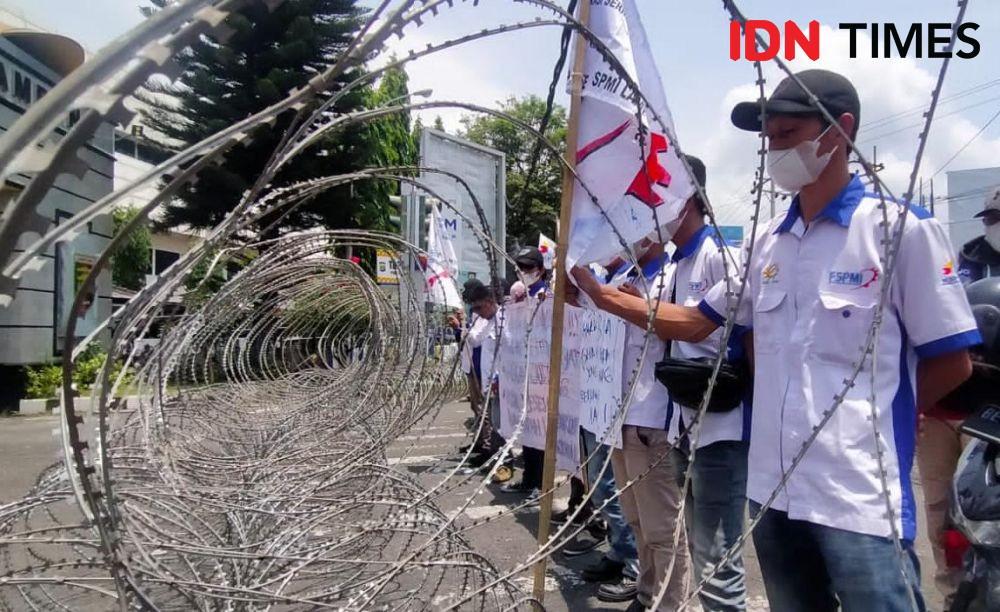 Puluhan buruh tergabung FSPMI menggelar aksi unjuk rasa di depan gerbang utama pintu masuk kompleks perkantoran Pemerintahan Provinsi Lampung. (IDN Times/Tama Yudha Wiguna)
