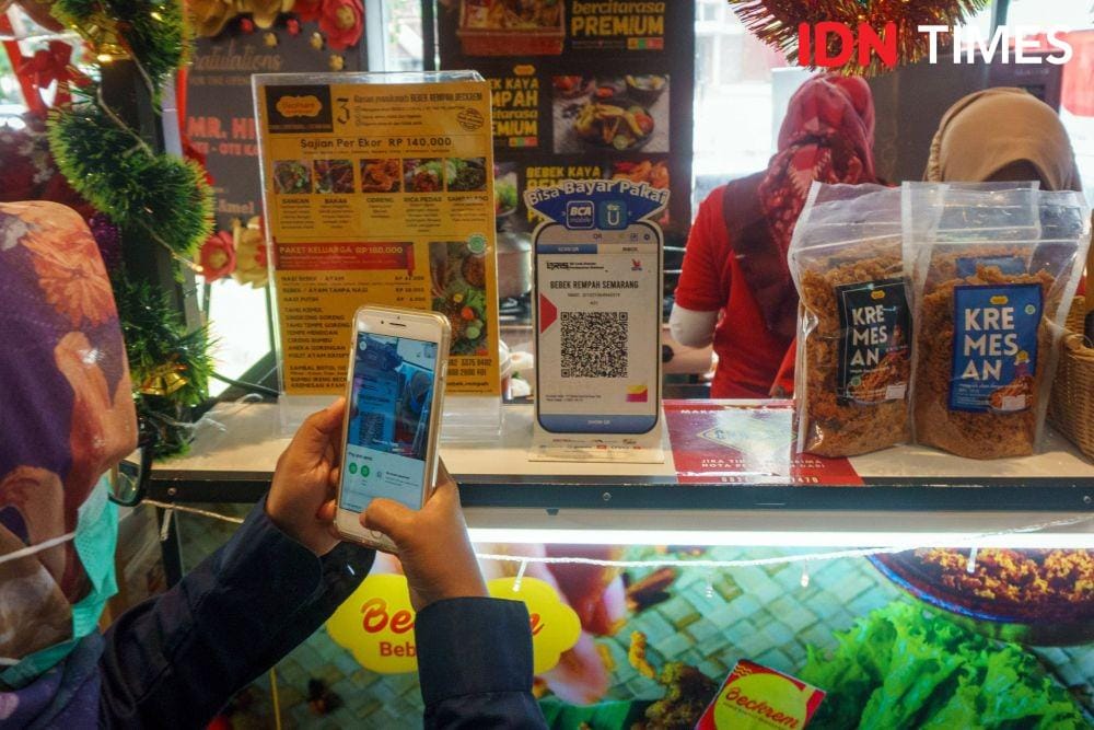 Pembeli memindai QR code pada merchant BCA UMKM Bebek Rempah untuk transaksi pembayaran di Semarang, Jawa Tengah (17/12/2021). Pembayaran tersebut memudahkan konsumen dan UMKM. (IDN Times/ Dhana Kencana)