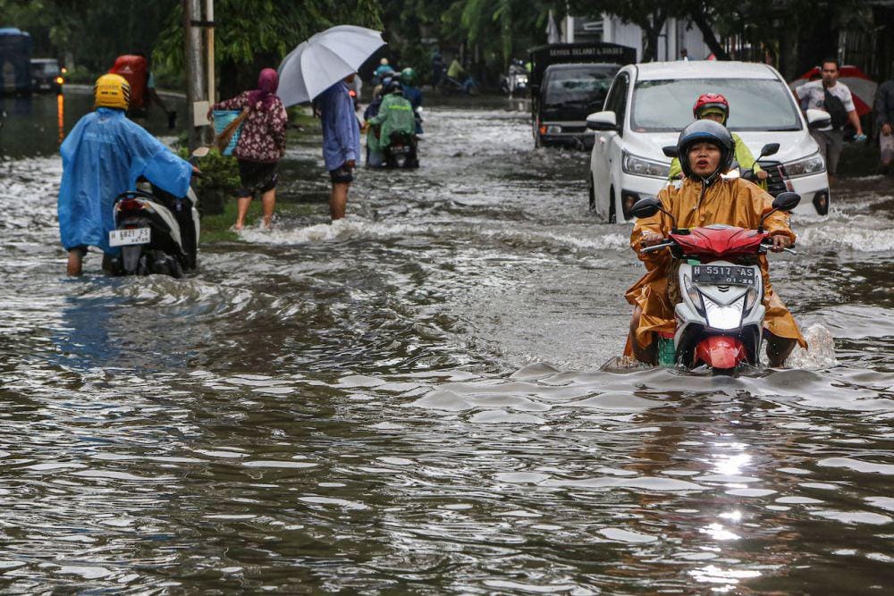 Pengendara motor dan mobil berusaha menembus banjir yang merendam di kawasan Jalan Raya Arteri Soekarno-Hatta, Semarang, Jawa Tengah, Kamis (14/3/2024). (ANTARA FOTO/Makna Zaezar)