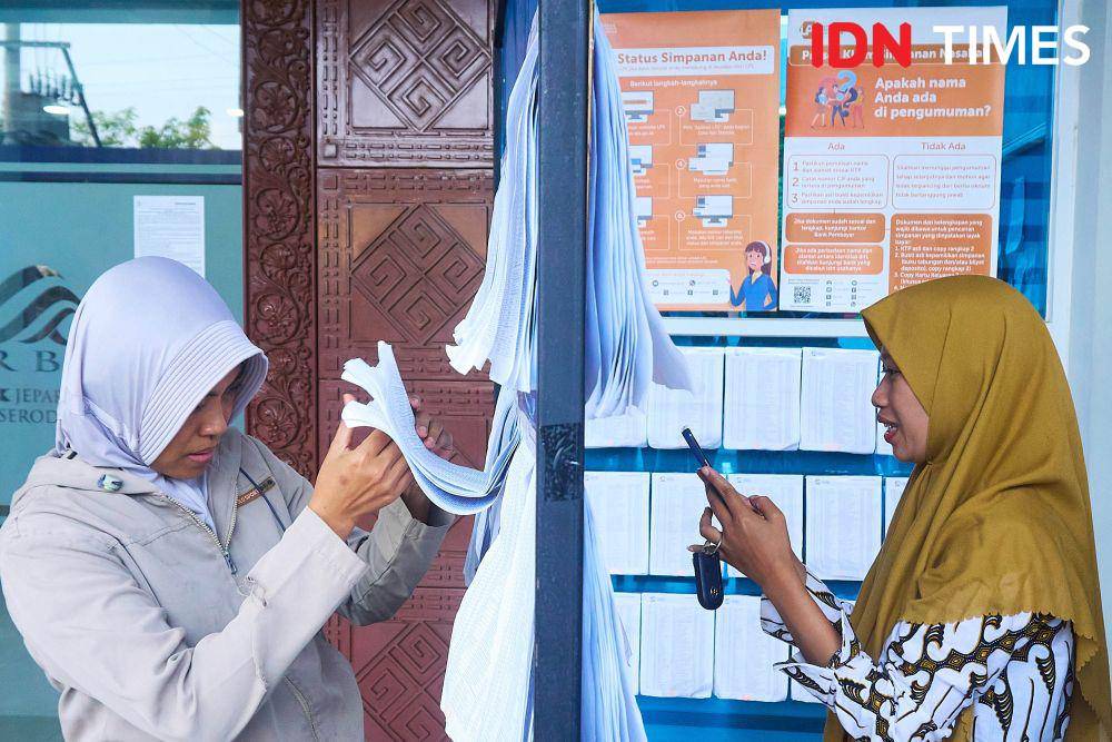 Sejumlah nasabah BPR Jepara Artha melihat daftar nama pembayaran klaim simpanan yang diumumkan oleh Lembaga Penjamin Simpanan (LPS) di Jepara, Jawa Tengah, Rabu (5/6/2024). (IDN Times/Dhana Kencana)