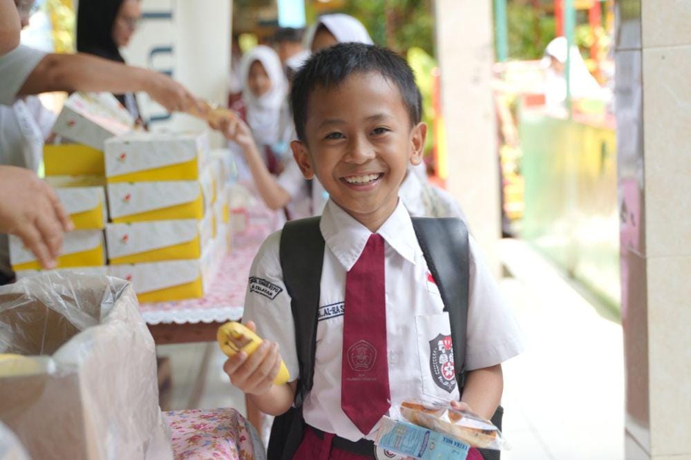 Anak SD memegang makanan