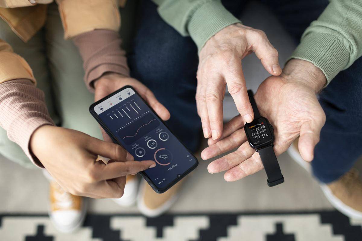 arabic-woman-teaching-senior-man-use-smartwatch-with-smartphone.jpg